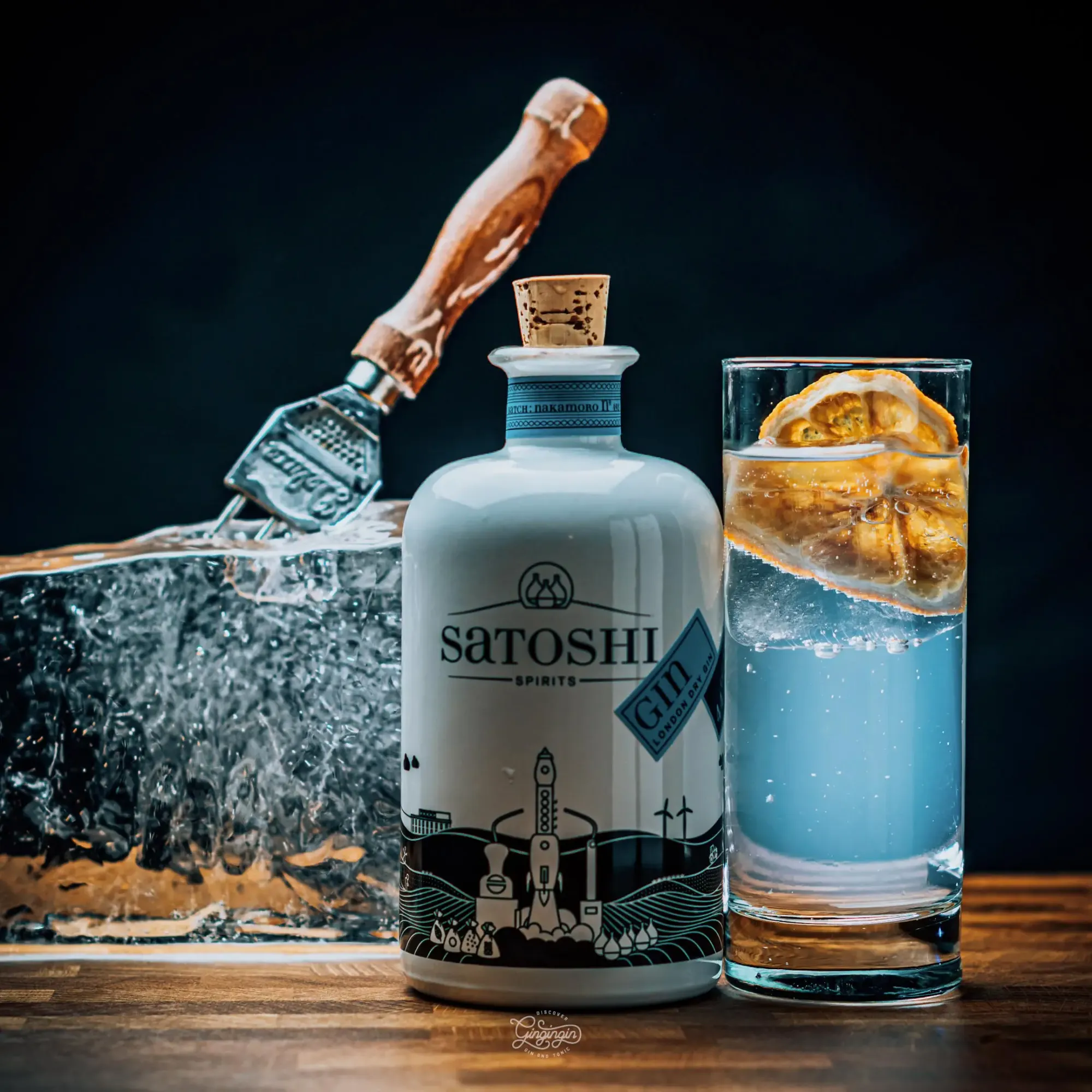 Large clear homemade ice cube with a light surface melt and a gin tonic with clear ice
