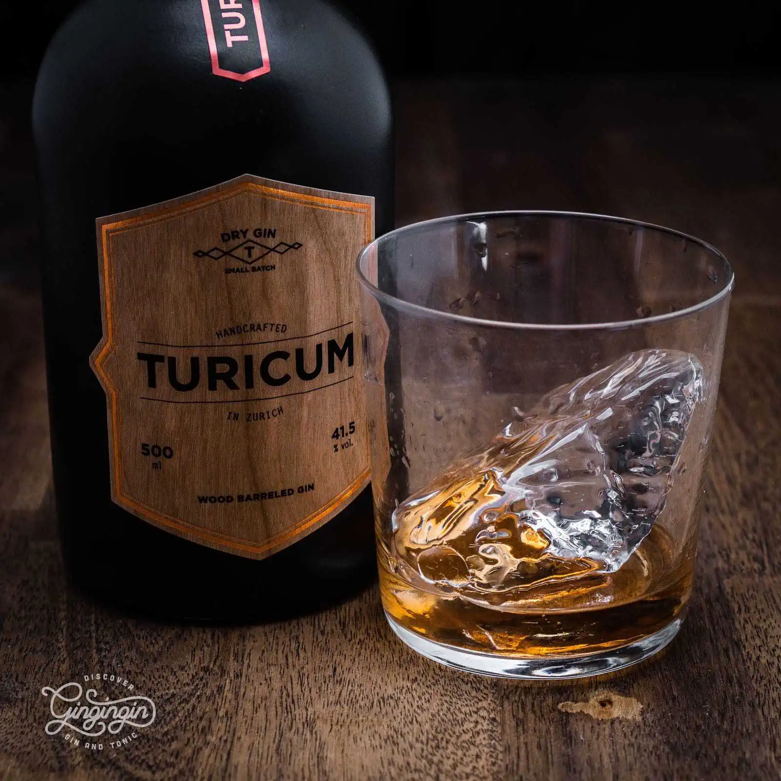clear ice in a tumbler glass with barrel rested golden coloured gin by turicum